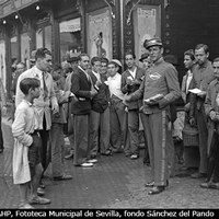 Reparto de publicidad en la embocadura de la calle Sierpes de los famosos calzados Segarra, la fábrica castellonense que acababa de abrir tienda en Sevilla y cuyo lema era “Cuestan menos, duran más”. Al fondo la centenaria confitería la Campana, un negocio familiar fundado en 1885 por Antonio Hernández Merino. 1935 ©ICAS-SAHP, Fototeca Municipal de Sevilla, fondo Sánchez del Pando