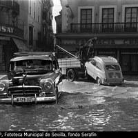 Efectos de la inundación de noviembre de 1961 en la Campana. A la izquierda el Bar Flor en los bajos del edificio de estilo ecléctico que data de 1899 y al fondo la Farmacia Central cuyo edificio sería desafortunadamente derribado en 1978. ©ICAS-SAHP, Fototeca Municipal de Sevilla, fondo Serafín