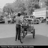 Un día de tráfico intenso en la Campana. En ella confluyen vehículos en dos direcciones. Taxis, camiones, carros, bicicletas y hasta una moto con sidecar se aprecian en la imagen. 1962 ©ICAS-SAHP, Fototeca Municipal de Sevilla, fondo Cubiles