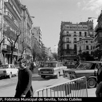 La Campana en 1977. A la derecha ya vemos el nuevo edificio del Banco Hispano Americano que ha borrado toda huella del antiguo Gran Café de París. La valla en primer término nos revela que el edificio de la Farmacia Central está ya a punto de ser derribado. ©ICAS-SAHP, Fototeca Municipal de Sevilla, fondo Cubiles