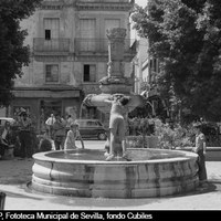 La fuente de la Encarnación, objeto del juego de los niños ante la pasividad de los adultos. Al fondo, el local de almacenes de confección Vázquez a punto de ser derruido. 1975-1977 ©ICAS-SAHP, Fototeca Municipal de Sevilla, fondo Cubiles